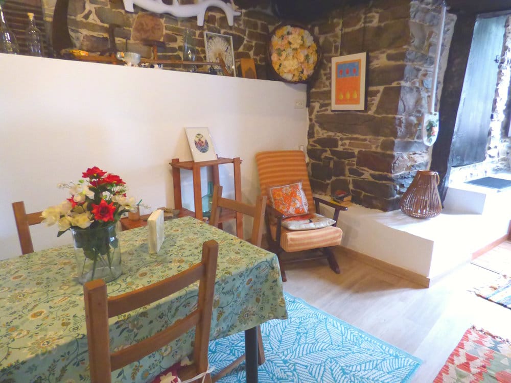 Comedor acogedor | Apartamento Luna Menguante, Casa Luna Comedor del apartamento Luna Menguante en Casa Luna de La Viliella, con mesa y sillas, cómoda mecedora junto a estantería con libros, paredes de piedra, suelo de parquet, alfombras y decoración con objetos típicos originales, en alquiler rural en la Reserva de la Biosfera de Muniellos. Comedor del apartamento Luna Menguante en Casa Luna de La Viliella, con mesa y sillas, cómoda mecedora junto a estantería con libros, paredes de piedra, suelo de parquet, alfombras y decoración con objetos típicos originales, en alquiler rural en la Reserva de la Biosfera de Muniellos.